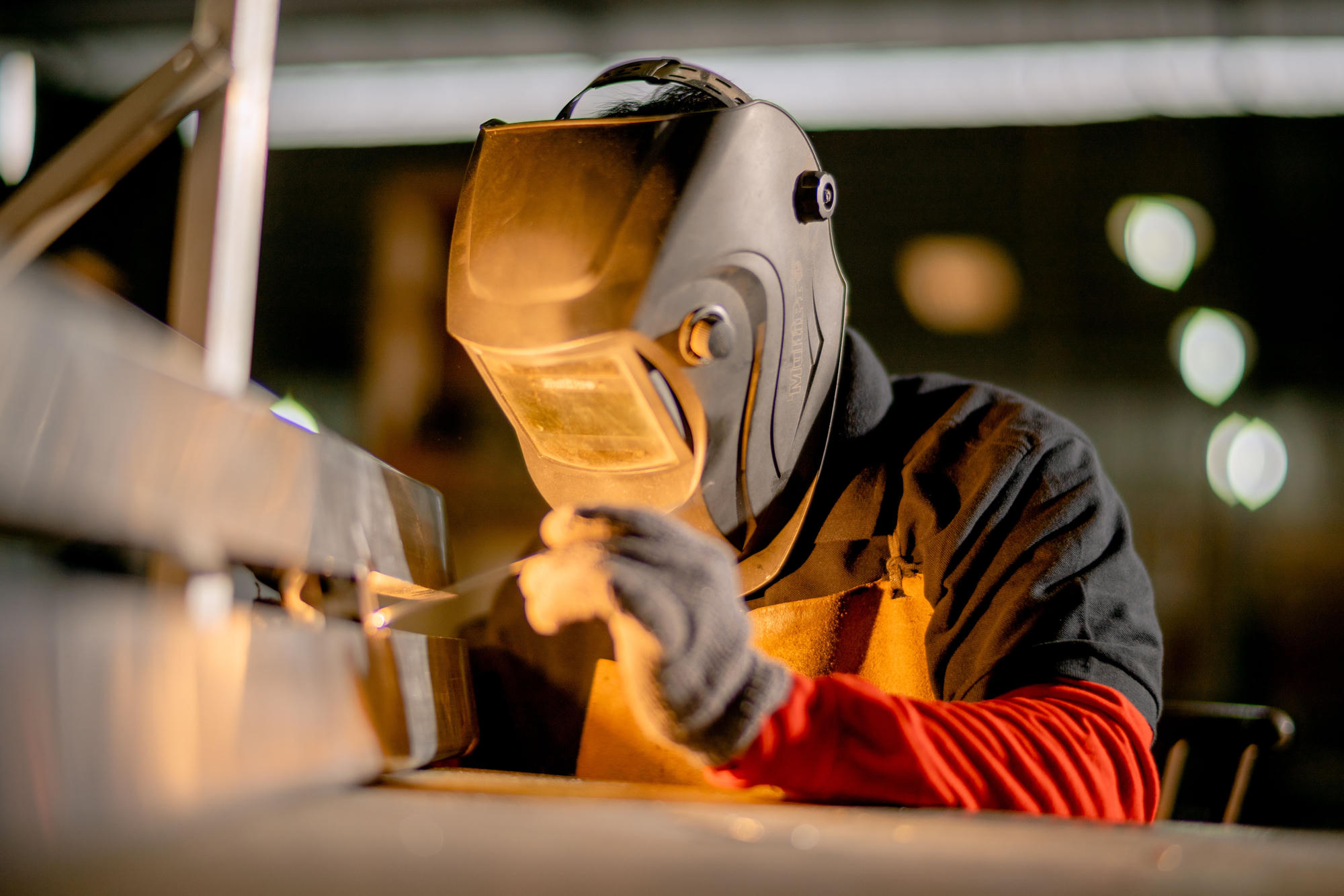 Welder joining a steel section in a fabrication shop